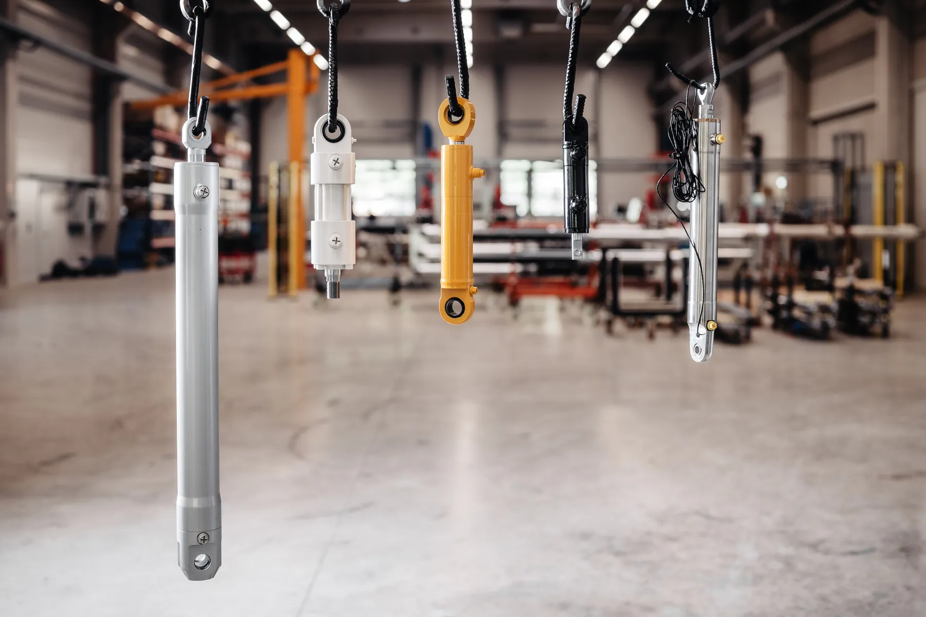 Verschiedene Hydraulikzylinder zur Qualitätsprüfung aufgehängt